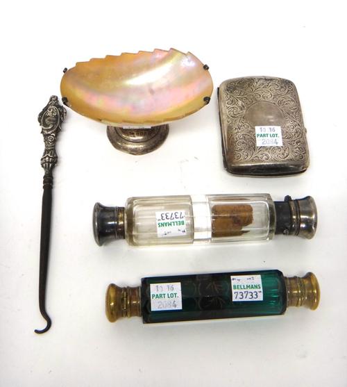 A Victorian silver mounted faceted glass double ended scent cum smelling salts bottle, London 1868, a brass mounted double ended green glass scent cum