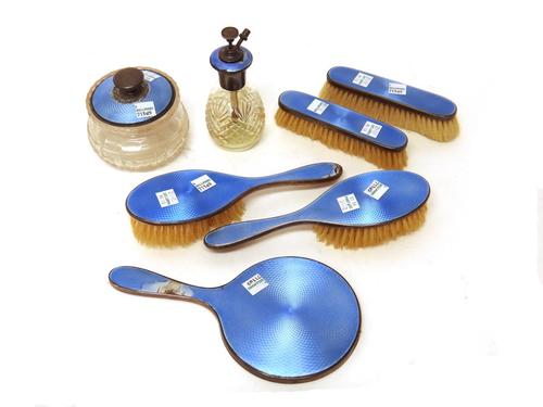 A lady's silver and pale blue enamelled seven piece part dressing set, comprising; a hand mirror, two clothes brushes, two hairbrushes, a faceted glas