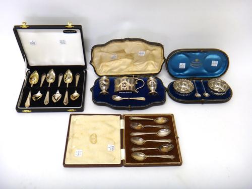 A silver three piece condiment set, comprising; an oval mustard pot and a pair of urn shaped pepperettes, with pierced and engraved decoration, London