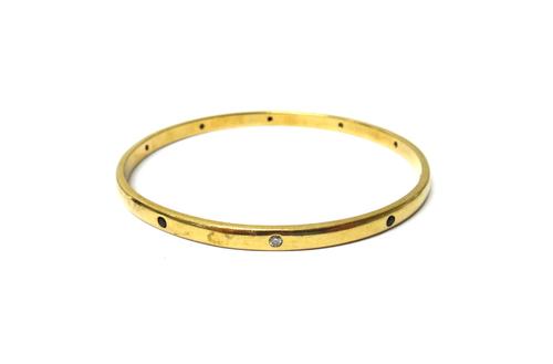 A gold, sapphire and diamond set circular bangle, mounted with circular cut diamonds alternating with circular cut sapphires, internal diameter 6.5cm,