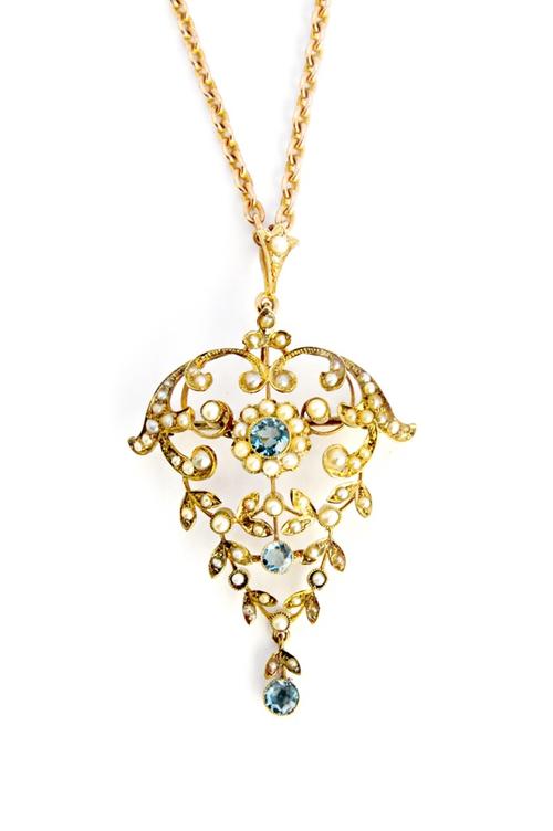 A gold, aquamarine and seed pearl set pendant brooch, in a scroll pierced foliate design, the centre with a cluster, mounted with three circular cut a