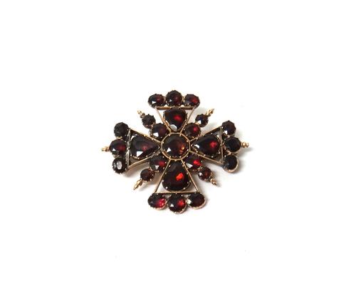 A garnet brooch, in a Maltese cross shaped design, mounted with variously cut flat cut garnets, with a case.