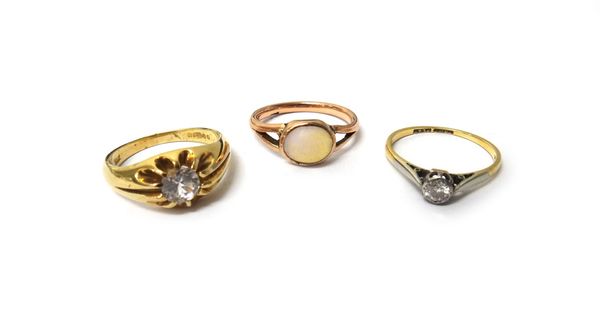 A gold and platinum, diamond set single stone ring, mounted with a circular cut diamond, a 9ct gold and colourless gem set solitaire ring and a gold r