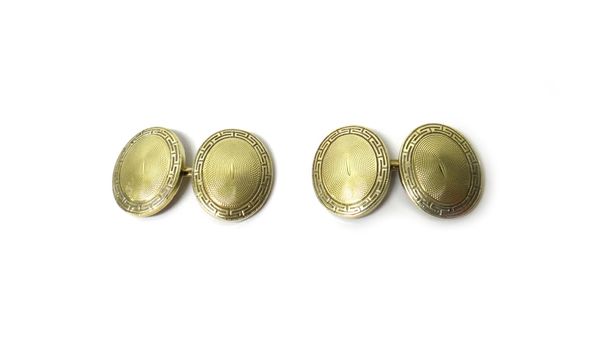 A pair of gold cufflinks, the backs and the fronts of dished oval form, with engine turned decoration to the centres within engraved Greek key pattern