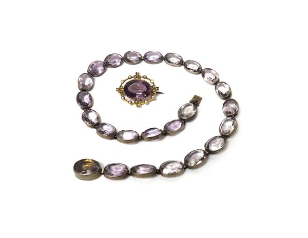 A gold, amethyst and seed pearl set oval brooch, claw set with the oval cut amethyst at the centre, with a box and a single row necklace of oval cut p