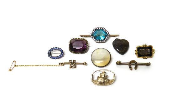 A pale blue and colourless paste set bar brooch, a Victorian black enamelled mourning brooch, glazed with a hair locket compartment, six further brooc