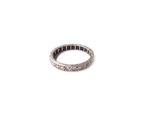 A diamond set full eternity ring, mounted with circular cut diamonds, the mount decorated with engraved sides, ring size J and a half.  Illustrated