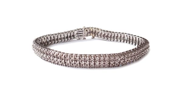 A white gold and diamond bracelet, mounted with three rows of circular cut diamonds, on a snap clasp, detailed 14 K, fitted with a safety chain, gross