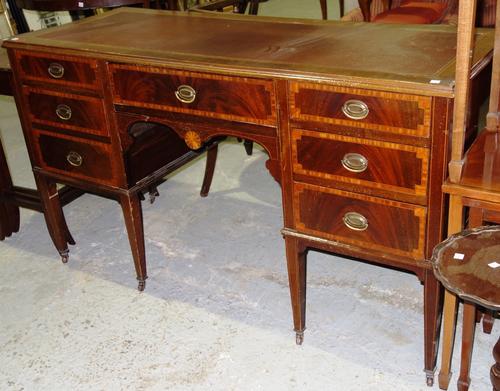 An Edwardian mahogany and satinwood banded kneehole desk, 134cm wide.  G2