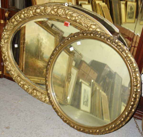 A circular gilt mirror, 63cm wide and an oval mirror, 92cm x 68cm. (2).  A4/A1