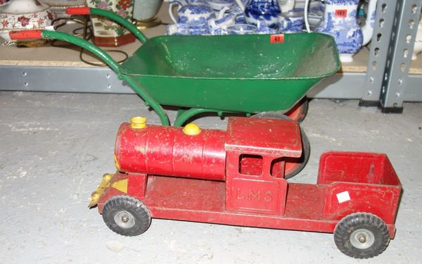 A miniature wheelbarrow with a metal toy train.   DIS