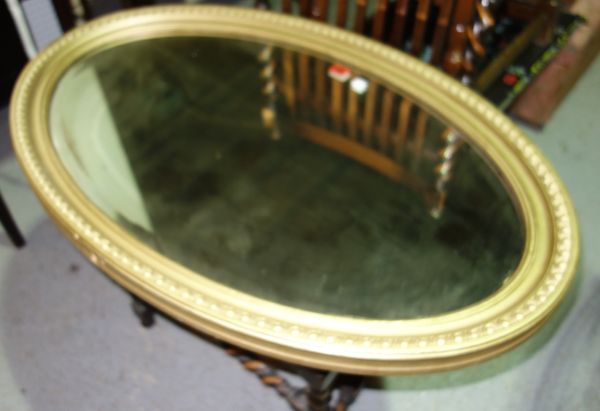An oval gilt framed wall mirror.  A4