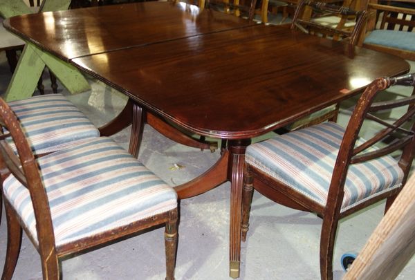 A Regency style mahogany 'D' end twin pedestal extending dining table on eight downswept supports with two extra leaves, 107cm wide x 158cm long and 2