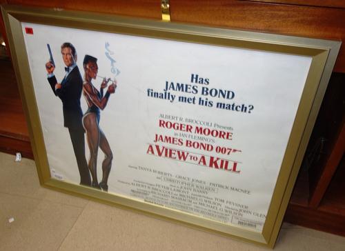 A framed and glazed film poster for; 'A View To A Kill' together with a group of James Bond collecting cards.  GA