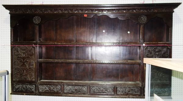 An 18th century and later carved enclosed Delft rack, with three shelves, flanked by cupboards over five spice drawers, 215cm wide x 116cm high. BEHIN