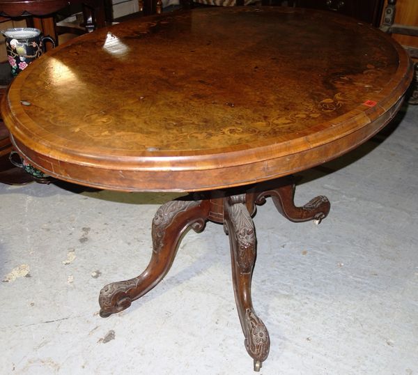 A Victorian marquetry inlaid walnut oval loo table, on four carved downswept supports.  I1