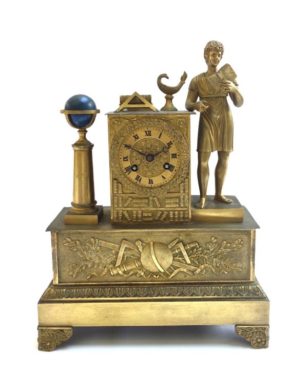 A French gilt metal mantel clock of Empire style, late 19th century, surmounted with a figure of a young boy reading a book, with globe and flaming oi