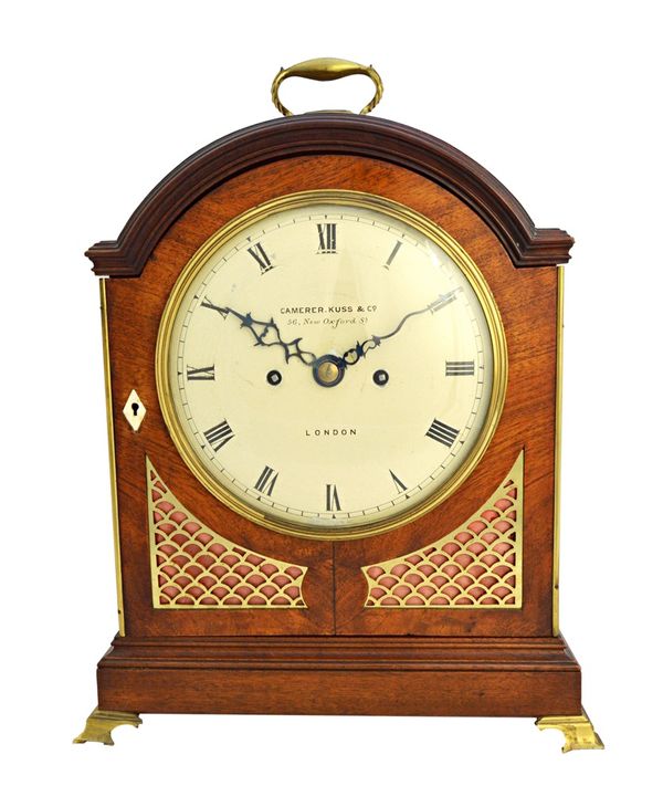 A mahogany cased bracket clock by Camerer, Kuss & Co, London, with arch pad top and painted tin dial, on a plinth base and brass feet, enclosing a cha