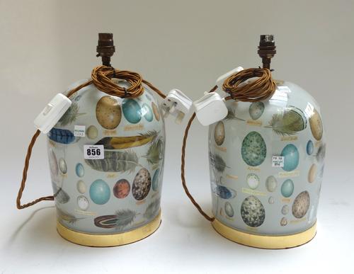 A pair of modern decolamania glass table lamps, each decorated with eggs and feathers and with a gilt band to the base, each 27cm high excluding fitme