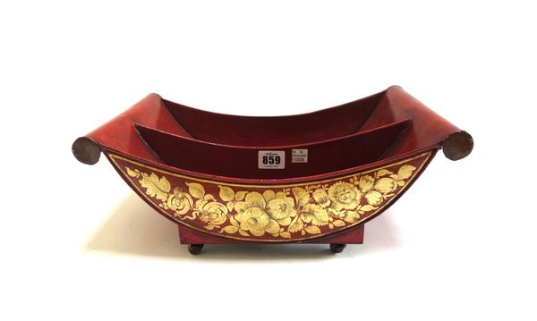 A Regency style Pontypool tole piente cheese coaster, with gilt floral decoration against a red ground, raised on brass castors (a.f), 38cm wide.