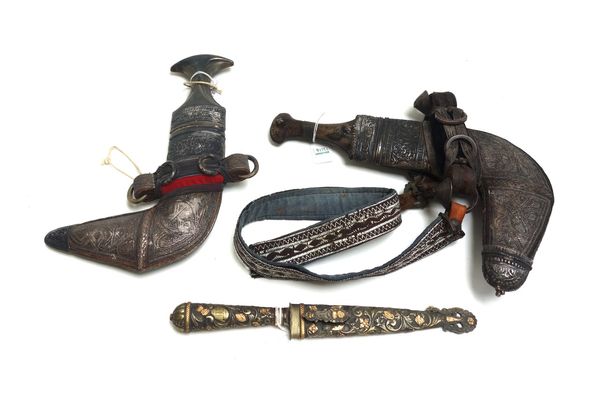 Two Middle Eastern jambiya, 20th century, with curved double edged steel blades, horn handles and a white metal clad scabbard, together with an Argent