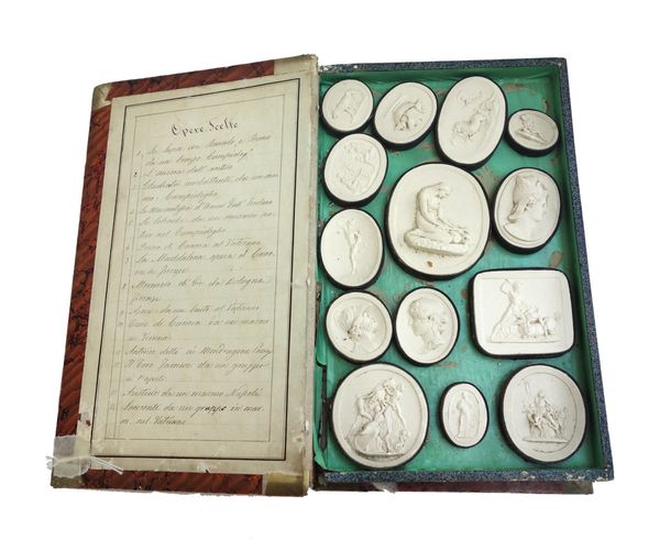 An early/mid 19th century Italian Grand Tour collection of twenty eight plaster casts after the antique, housed in a faux book, with handwritten key t