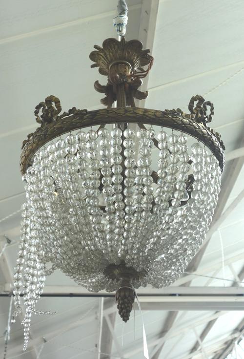 A bronze and beadwork bag chandelier, late 19th century, the acanthus cast circlet, with four bow surmounts, suspending chains of glass beads, termina