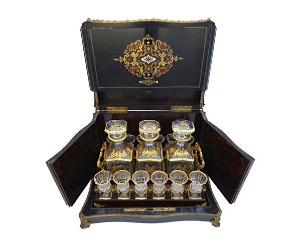 A French brass and tortoiseshell 'Bouille' inlaid ebonised decanter case, circa 1870, with ormolu mounts, enclosing three gilt decanters and twelve gl