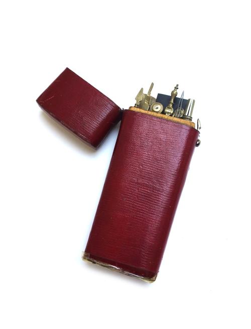 A collection of mid 20th century drawing instruments, contained in a red leather bound wooden hinged case (a.f), 17cm high.