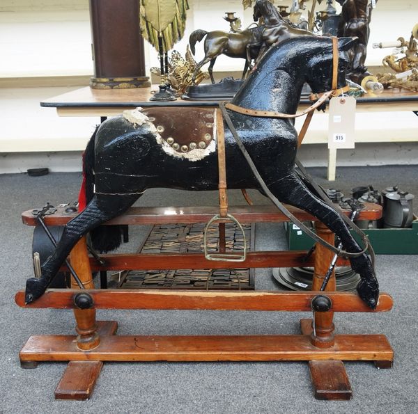 A black painted wooden rocking horse, 20th century, later alterations, on a pine swing frame base (a.f), the iron strapwork stamped 'L.B Ltd SPI', 95c