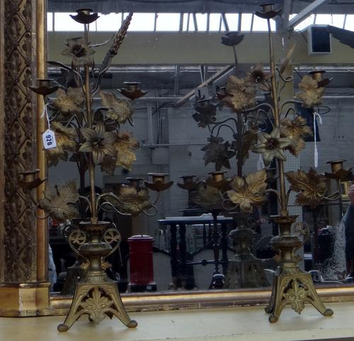 A pair of Aesthetic Movement gilt metal five branch floral candelabra, late 19th century, each on a pierced triform base, (a.f), 64cm high, (2).