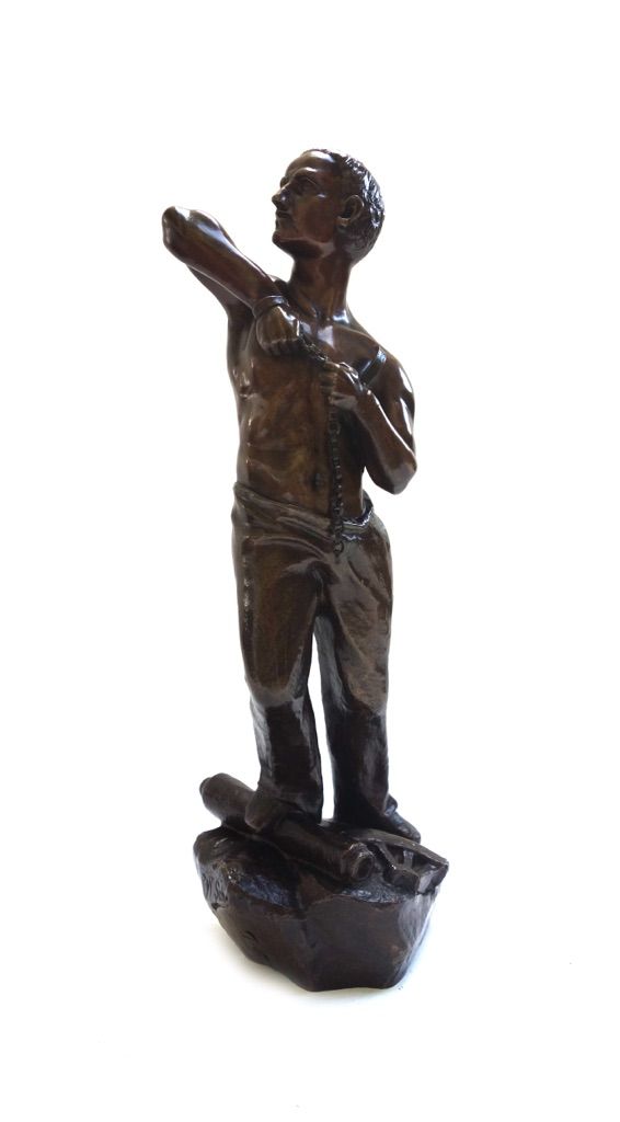 A bronze figure, late 19th/early 20th century, depicting a semi naked European man breaking free from his manacles, his right foot raised on a cannon