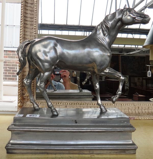 A white metal horse, late 20th century, right front foot raised, mounted on an integral stepped rectangular plinth, stamped marks to base, 37.5cm high