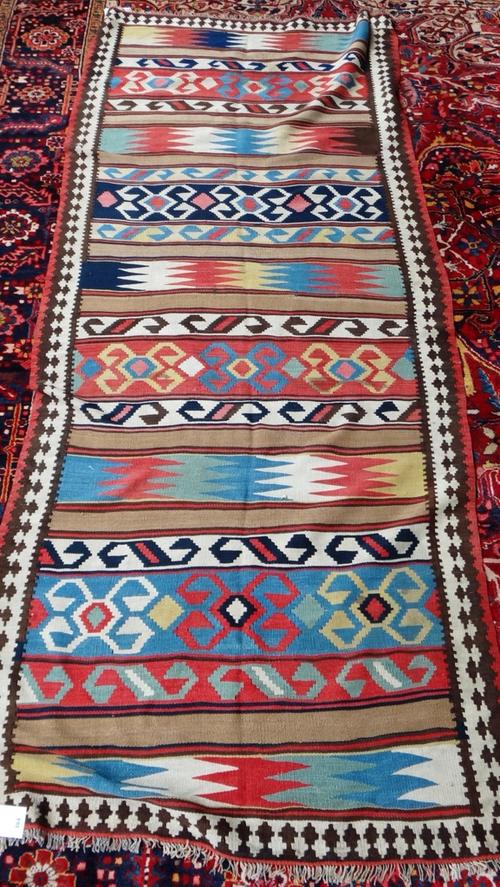 A Shiraz gelim, South Persian, the polychrome field with bands of design, an interconnecting arrow border, 322cm x 135cm.