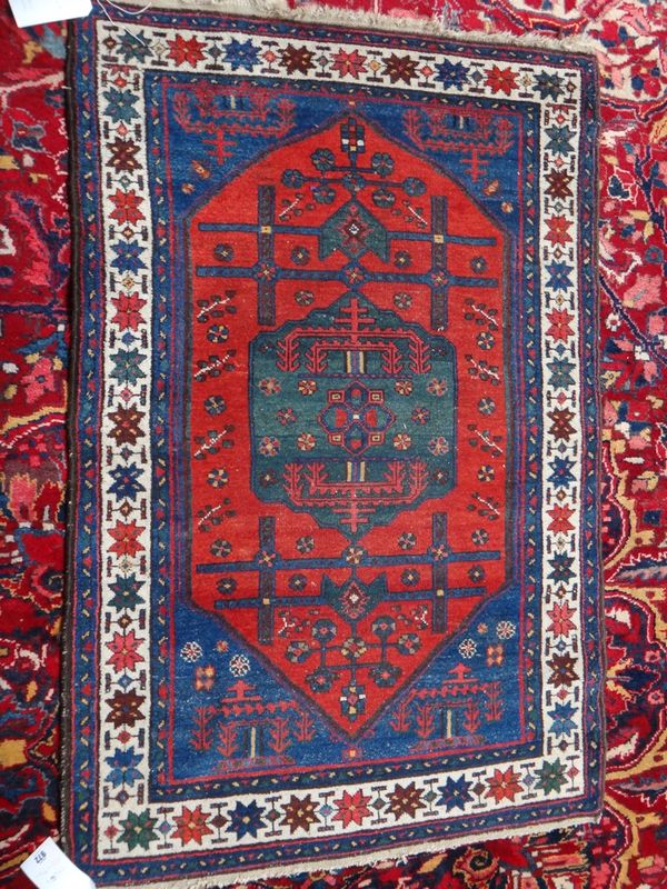 A North West Persian rug, the madder field with a sage medallion, indigo spandrels, an ivory star border, 150cm x 97cm.