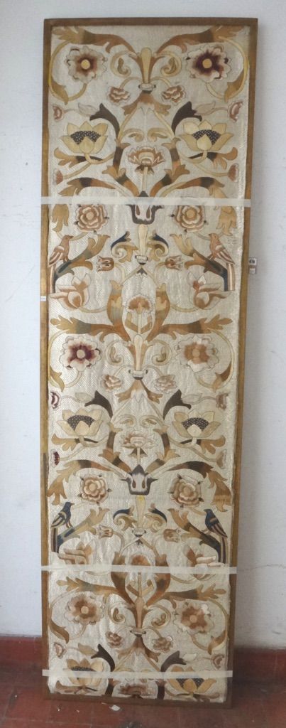 A silk embroidered panel, probably Portuguese, late 18th century, woven with pairs of birds and large foliage against a gold ground, framed, 236cm x 6