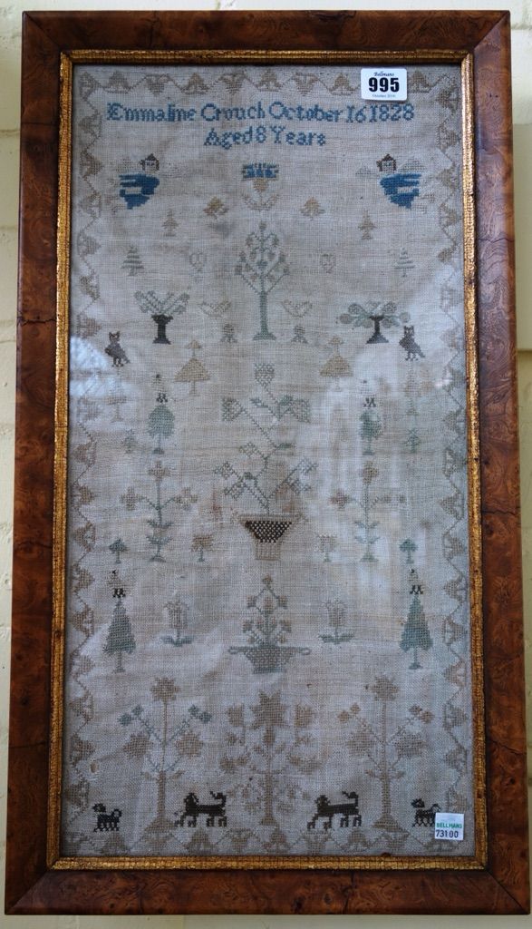 A George IV needlework sampler, dated 1828, designed with plants, trees and a pair of angels, framed and glazed, 51.5cm x 26cm.