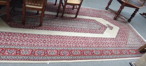 A part silk Kashan carpet, Persian, the plain ivory field with an elongated herate medallion, surrounded by a similar design, a madder palmette and vi