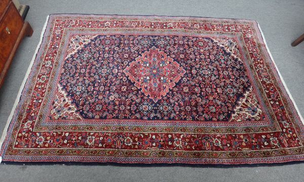 A Malayer rug, Persian, the madder field with a pink diamond, ivory spandrels, an all over herate design, a madder floral border, 211cm x 148cm.