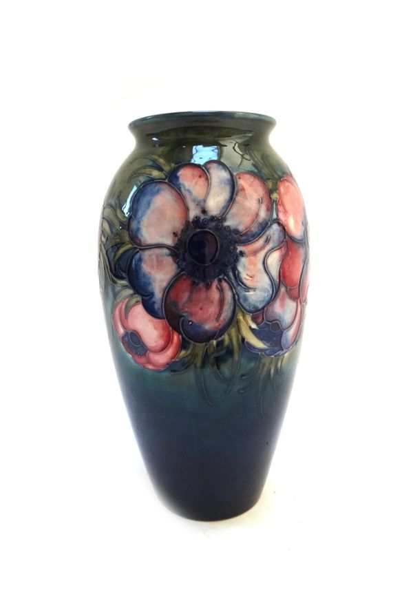 A Moorcroft 'anemone' vase decorated with a band of flowers against a green/blue ground, with stamped and painted marks (a.f), 25cm high.