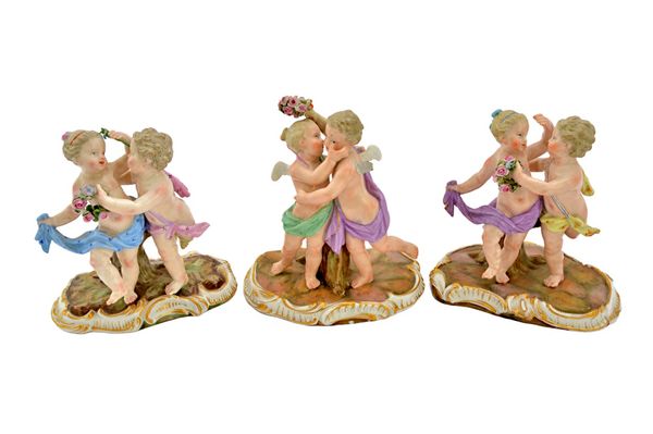 Three Meissen porcelain figure groups, late 19th century, each modelled as two cherubic figures holding floral garlands, on a naturalistic C scroll ba
