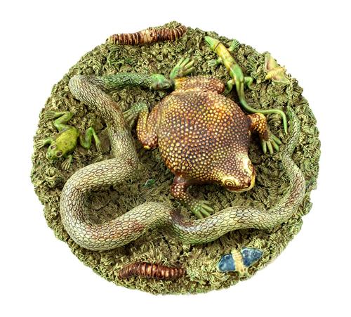 A Portuguese pottery plate, late 19th/early 20th century, decorated with applied frog, snake, beetles and butterflies against a naturalistic ground, i