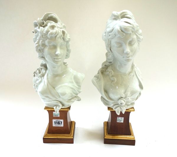 A pair of Royal Worcester white glaze porcelain busts, 'Night' and 'Day', by Arnold Machin, circa 1970, with incised marks, on wooden waisted plinths,