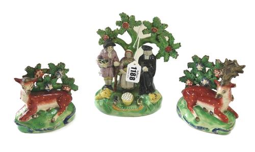 A Staffordshire pearlware Tithe pig group, circa 1820, of traditional form, the three characters standing before a tree on a grassy mound base, (a.f),