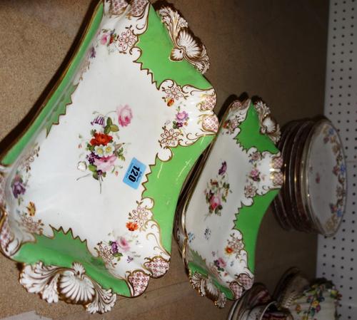 A pair of English porcelain shaped rectangular dishes, circa 1820-30, painted with groups of flowers against an apple green ground and raised on four