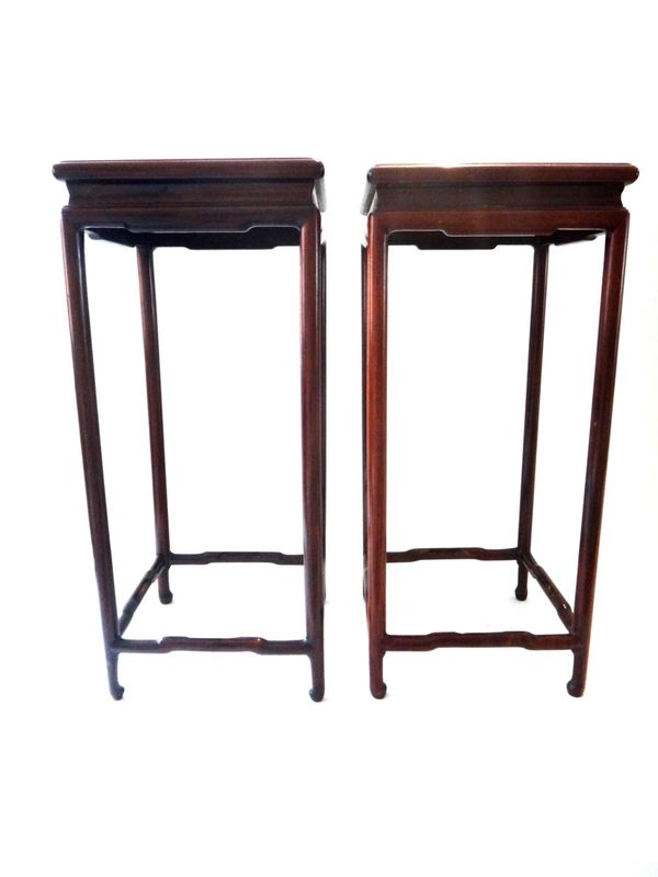 A pair of Chinese hardwood stands, 20th century, with square tops on cylindrical supports with stretchers, 54cm. high.