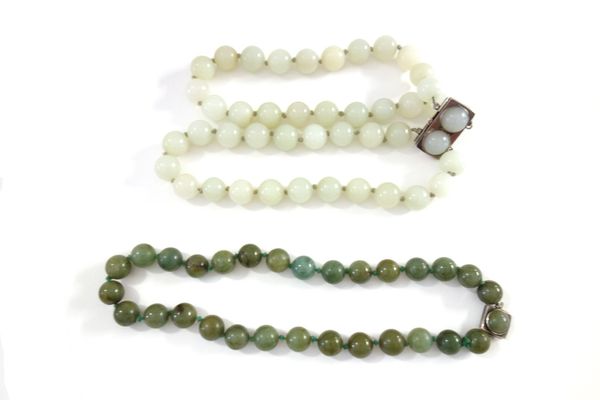 A Chinese pale celadon jade choker necklace, 20th century, with silver clasp; also a matching bracelet, a spinach jade necklace and earrings.