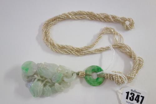 A Chinese jadeite pendant, 20th century, carved as branches of peaches and finger citron, the stone with lavender and green inclusions, suspended from