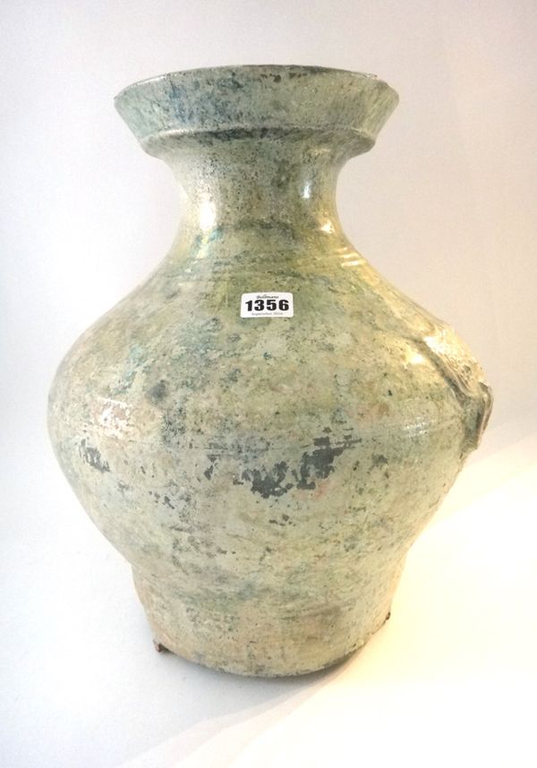 A Chinese green glazed pottery wine jar, Hu, Han Dynasty, of baluster form with mask and ring handles, 42cm. high; also a green glazed cylindrical tri