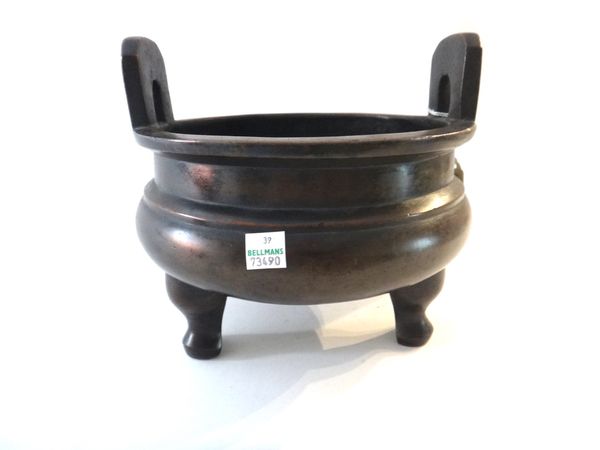 A Chinese bronze censer, Xuande six character mark, but later, set with upright handles and raised on three supports, 21cm.diameter.
